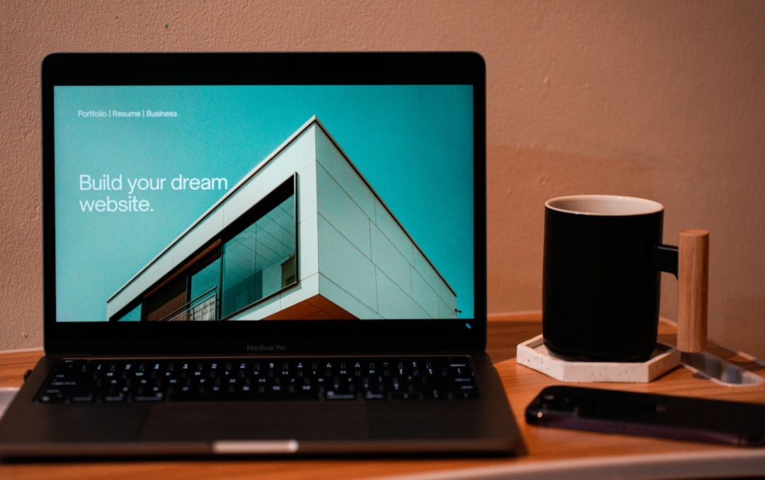 services-bg Build your dream website for your future. A laptop, MacBook, on top of a portable table with coffee tea mug on the side.