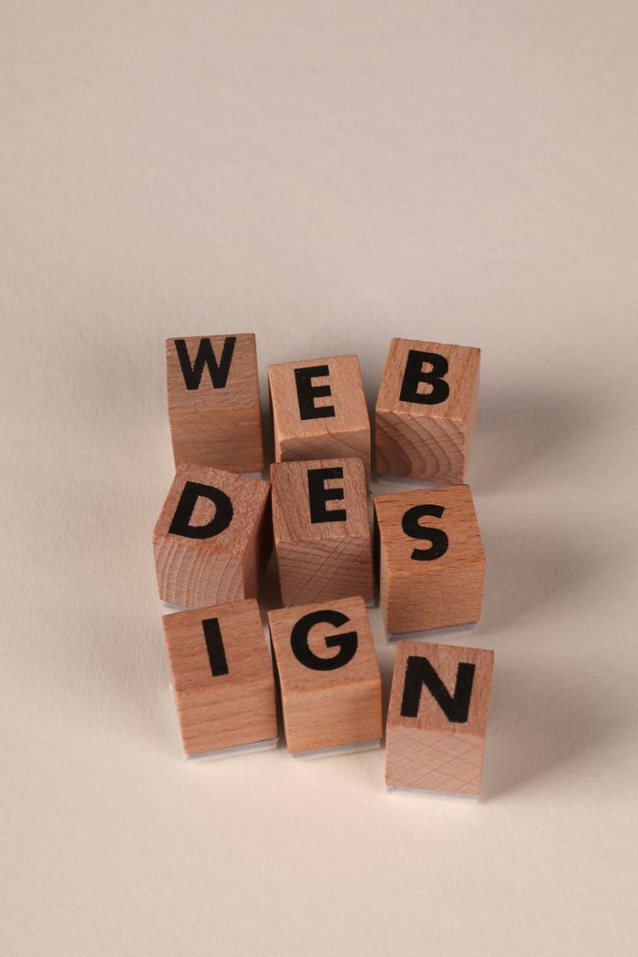 services-05 Wooden blocks arranged to spell Web Design. Perfect for creative, digital content themes.